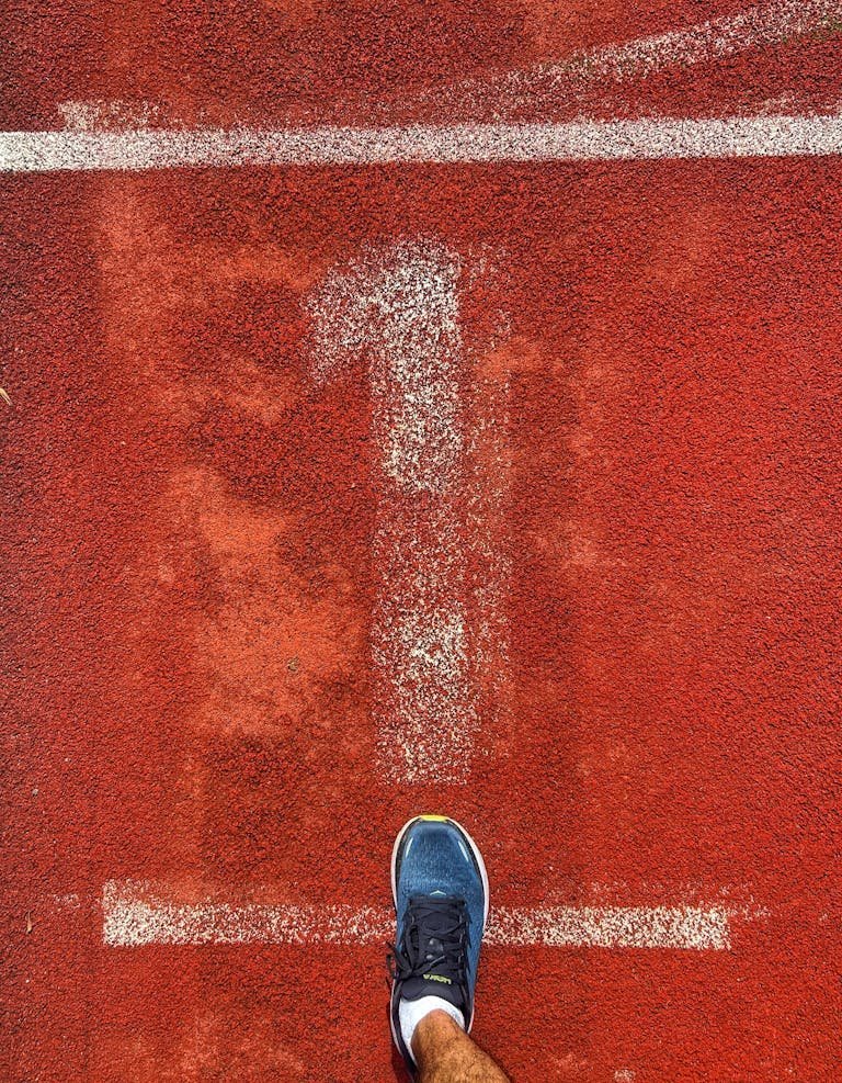 Person's foot on start line of a running track in Frankfurt, Germany.