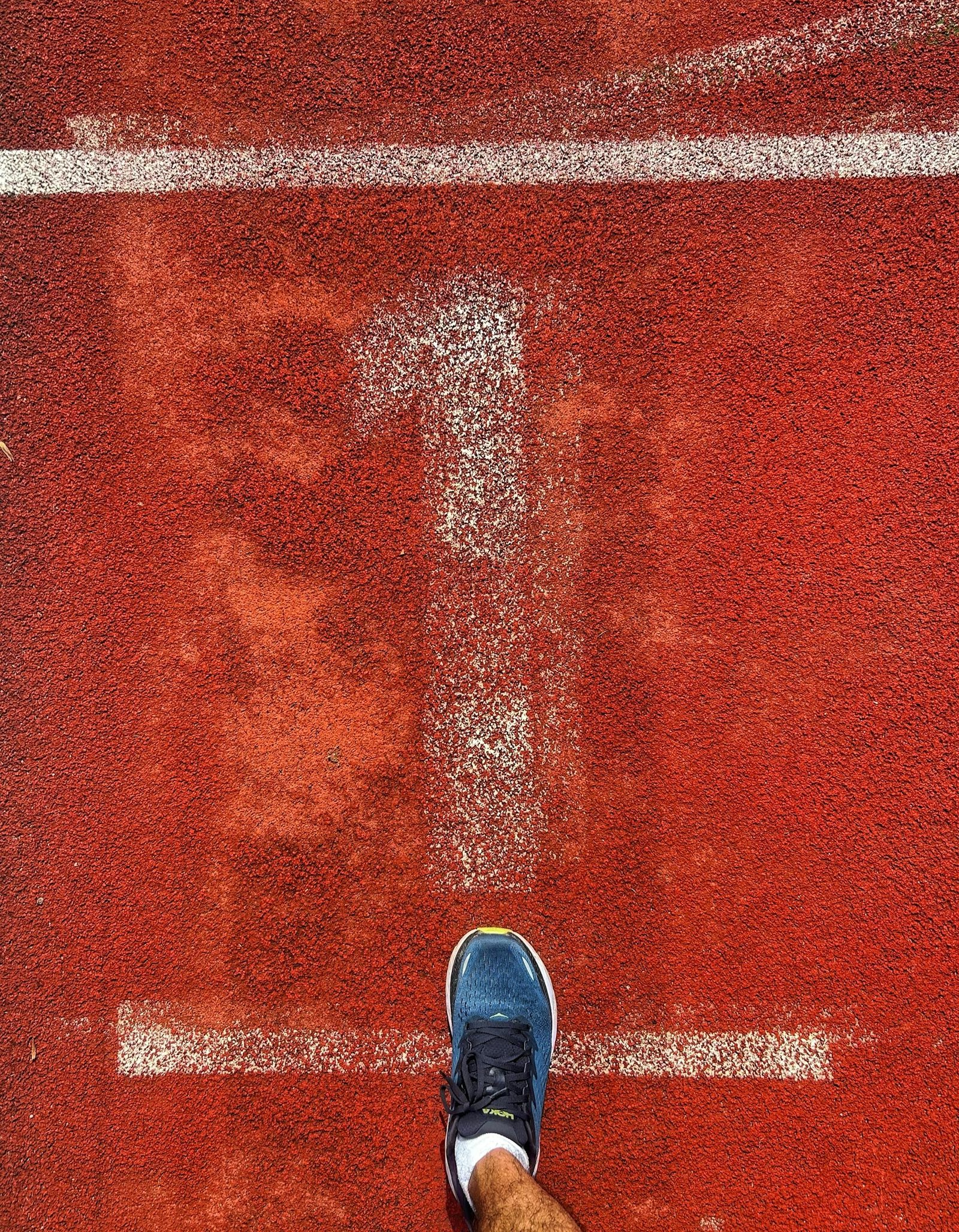 Person's foot on start line of a running track in Frankfurt, Germany.